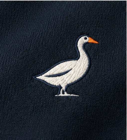 Embroidered White Goose Bay signature on navy fabric