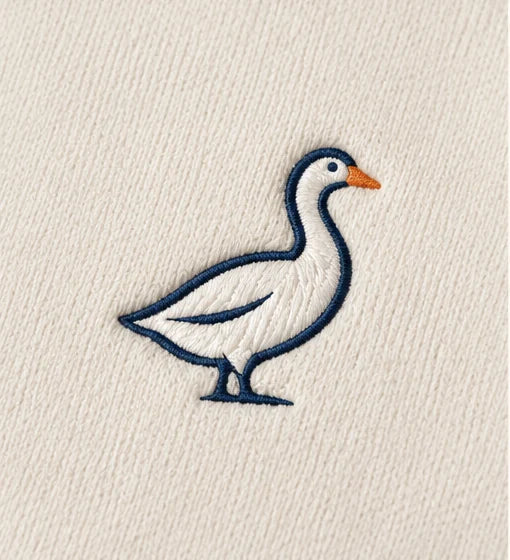 The goose embroidery shown on ivory quarter-zip fabric