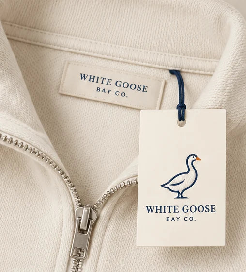 White Goose Bay neck label and hang tag on ivory quarter-zip